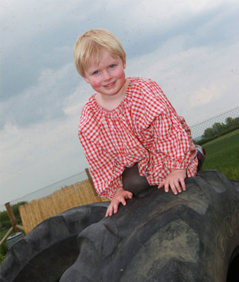Montessori nursery child climbing on tyres